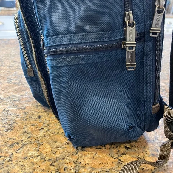Tumi blue and black backpack. All zips & interior excellent. Two small spots.